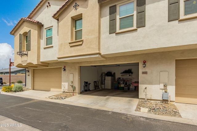 multi unit property with stucco siding and an attached garage