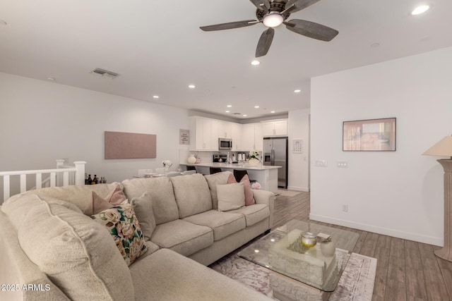 living area featuring recessed lighting, light wood finished floors, ceiling fan, and baseboards