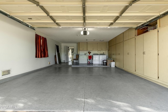 garage with washer and dryer and a garage door opener