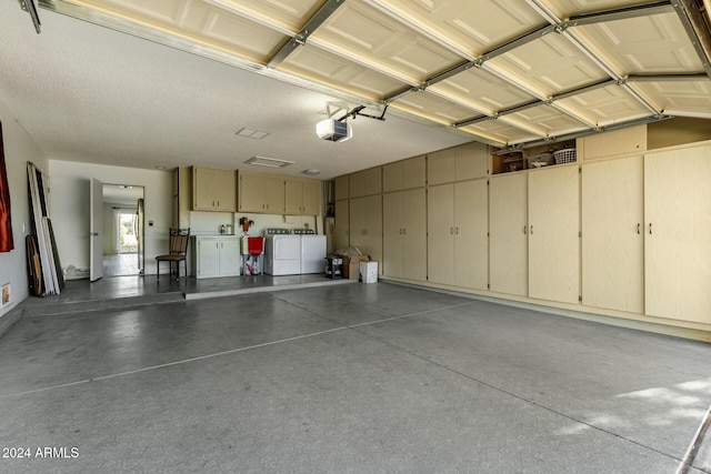 garage with independent washer and dryer and a garage door opener