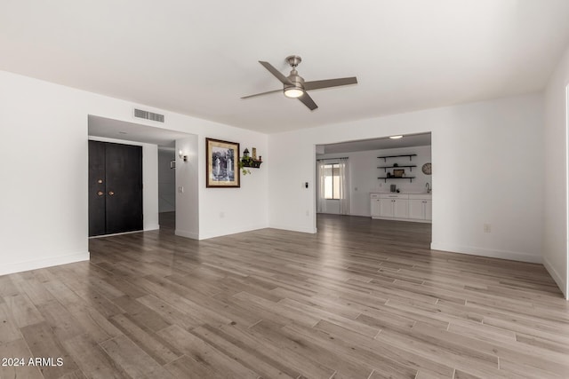 unfurnished living room featuring light hardwood / wood-style flooring and ceiling fan