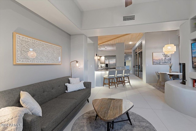 living room featuring light tile patterned flooring, beam ceiling, and wood ceiling