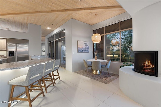 kitchen with decorative light fixtures, built in refrigerator, beamed ceiling, and wooden ceiling