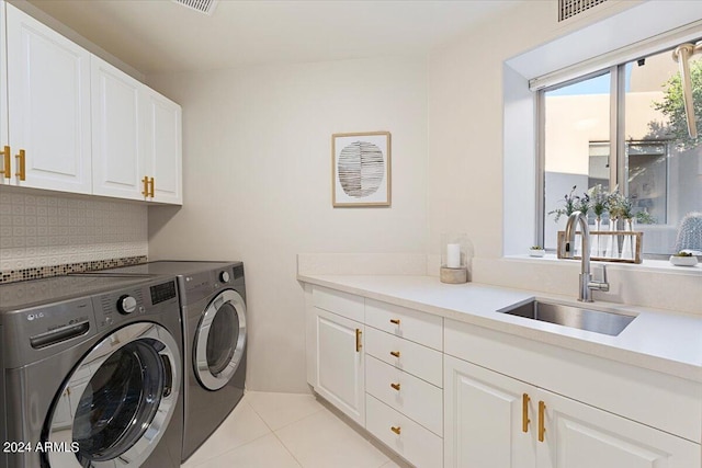 laundry room featuring sink, light tile patterned flooring, separate washer and dryer, and cabinets