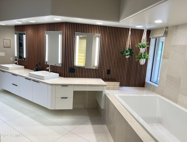 bathroom with tiled bath, plenty of natural light, tile patterned floors, and vanity