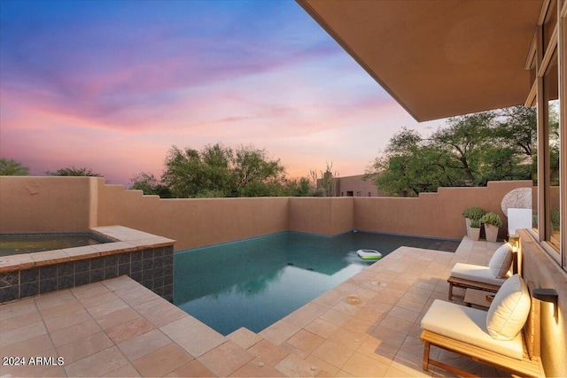 pool at dusk with a patio