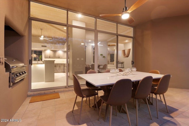 dining space with ceiling fan, expansive windows, and light tile patterned flooring