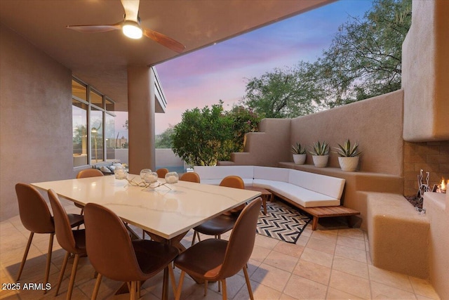 patio terrace at dusk with an outdoor living space and ceiling fan