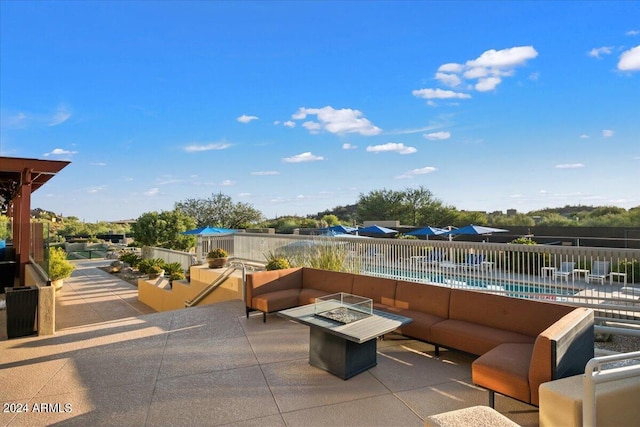 view of patio / terrace featuring a fenced in pool and an outdoor living space with a fire pit