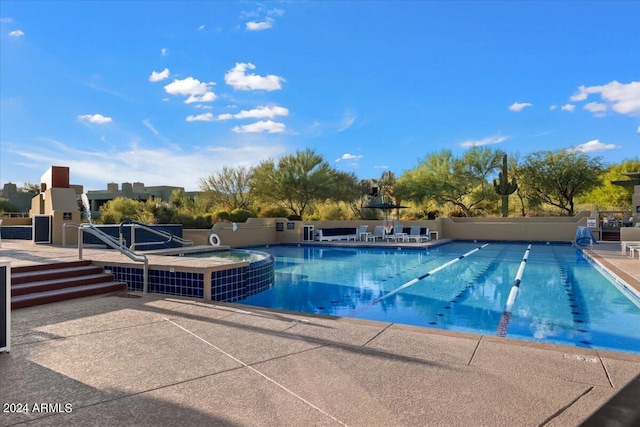 view of swimming pool with a patio area and an in ground hot tub