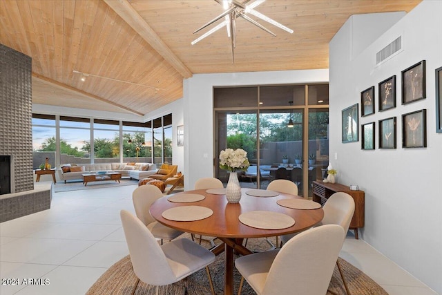 dining space featuring a brick fireplace, high vaulted ceiling, wood ceiling, and light tile patterned flooring