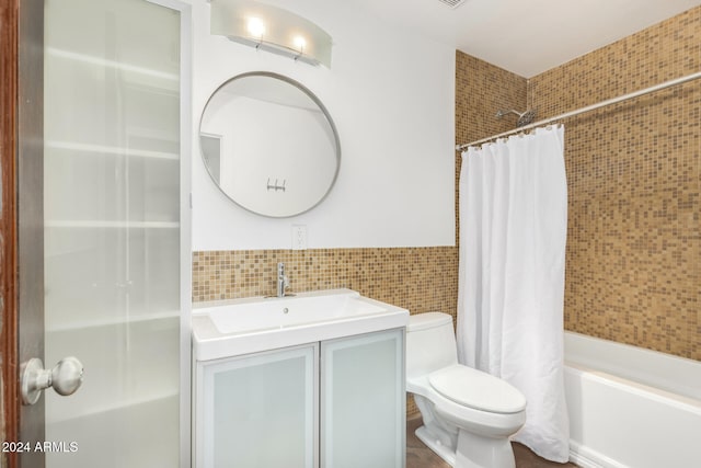 full bathroom with shower / tub combo with curtain, vanity, tile walls, and toilet