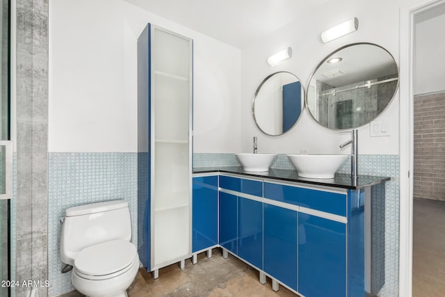 bathroom featuring vanity, toilet, and tile walls