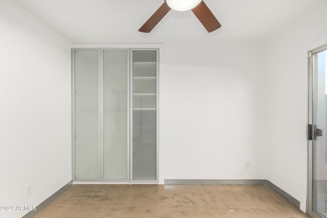 interior space with ceiling fan, a closet, and light colored carpet