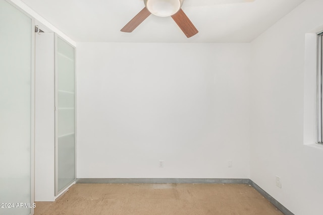 carpeted spare room featuring ceiling fan