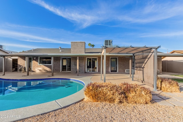 view of pool with cooling unit, a pergola, and a patio