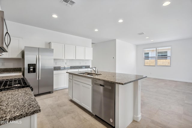 40040 W Agave Rd, Maricopa, AZ 85138 - kitchen featuring appliances with stainless steel finishes, dark stone countertops, white cabinetry, recessed lighting, and a center island with sink