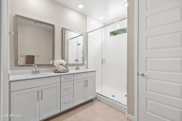 full bathroom featuring double vanity, a sink, tile patterned floors, and a shower stall