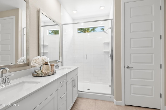 full bath featuring a sink, tile patterned flooring, a stall shower, and double vanity