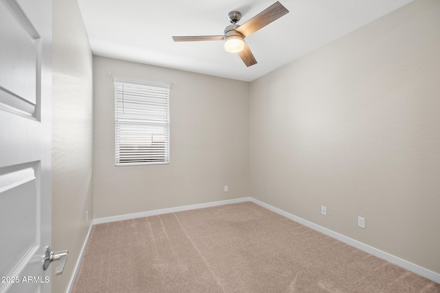 carpeted empty room featuring baseboards and ceiling fan