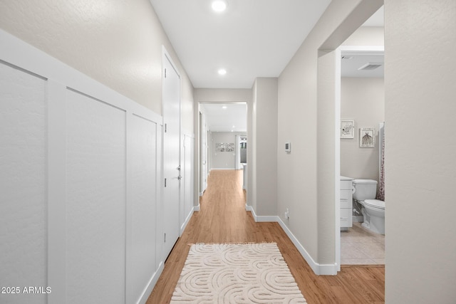 corridor featuring recessed lighting, baseboards, visible vents, and light wood-style flooring