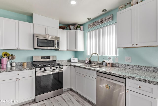 7357 W Cheryl Dr, Peoria, AZ 85345 - kitchen featuring white cabinetry, recessed lighting, light stone counters, a sink, and stainless steel appliances
