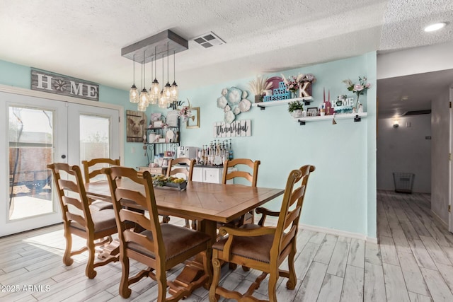 7357 W Cheryl Dr, Peoria, AZ 85345 - dining space featuring light wood-type flooring, visible vents, a textured ceiling, and french doors