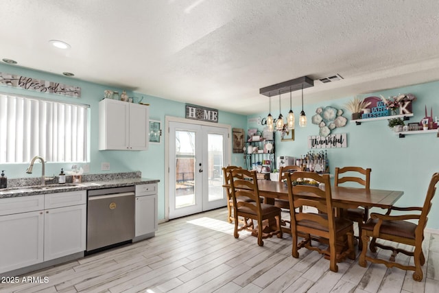 7357 W Cheryl Dr, Peoria, AZ 85345 - dining area with light wood-style flooring, a textured ceiling, french doors, and visible vents