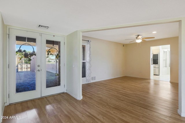 interior space with french doors, visible vents, baseboards, and wood finished floors