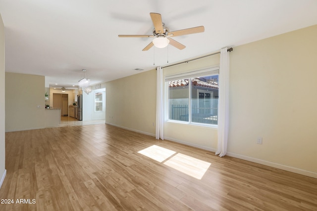 unfurnished living room with light wood-style flooring, visible vents, baseboards, and ceiling fan