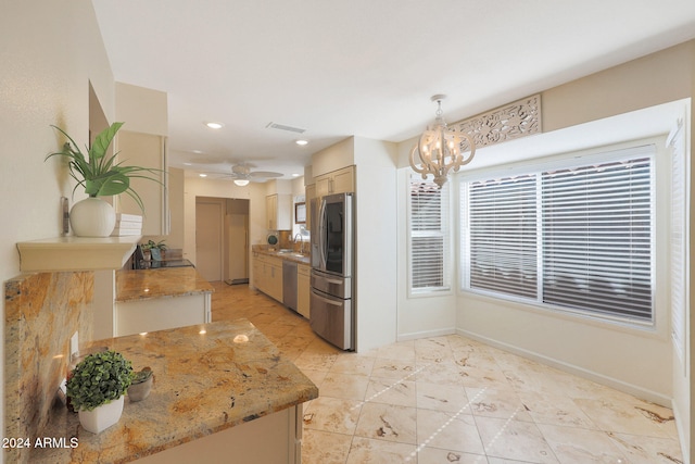 kitchen with light stone counters, visible vents, baseboards, hanging light fixtures, and appliances with stainless steel finishes