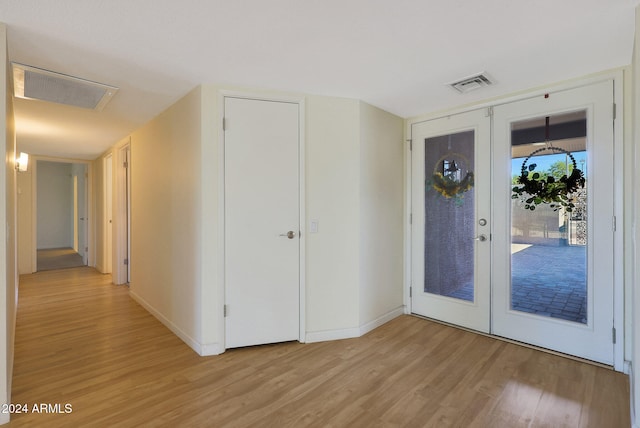 doorway featuring light wood-type flooring, french doors, visible vents, and baseboards