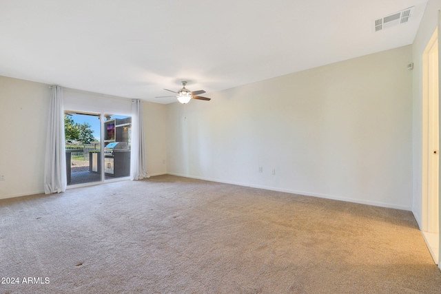 empty room featuring carpet, visible vents, ceiling fan, and baseboards