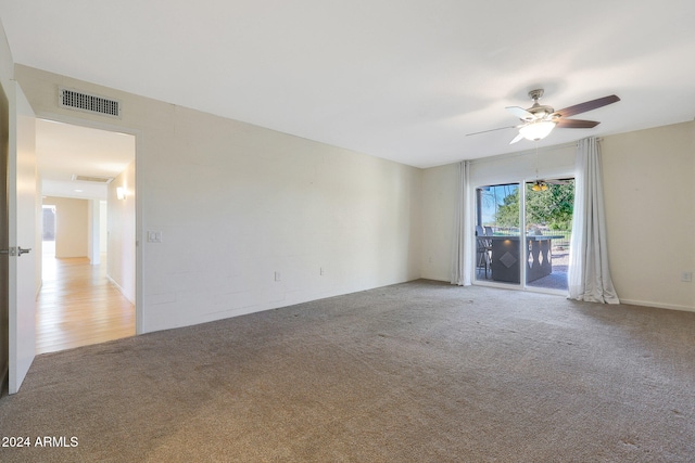 empty room featuring light carpet, ceiling fan, and visible vents