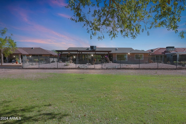 rear view of property with fence and a yard