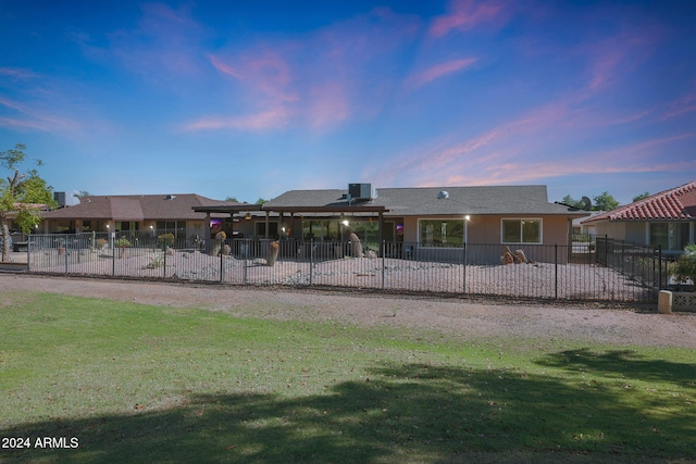 view of front facade featuring a patio, a lawn, and fence