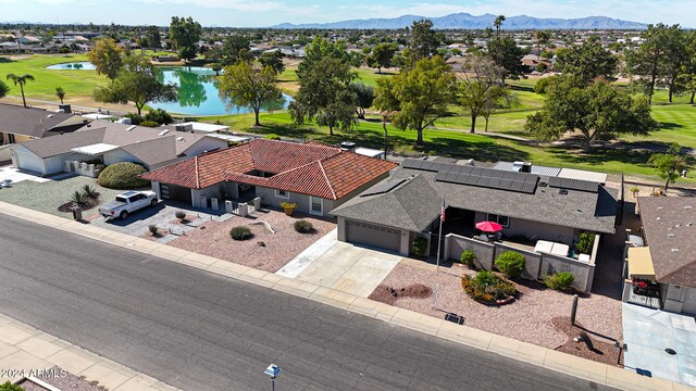 drone / aerial view with a mountain view, golf course view, and a residential view