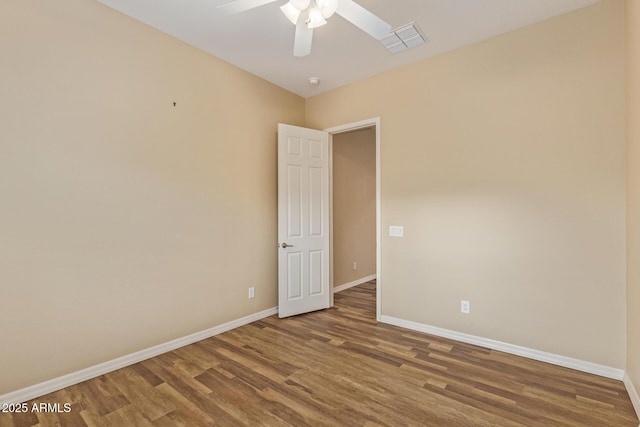 empty room featuring baseboards, ceiling fan, and wood finished floors