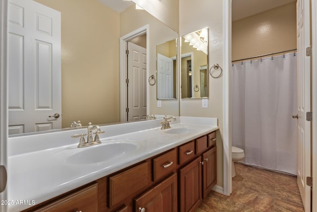 bathroom with curtained shower, double vanity, toilet, and a sink