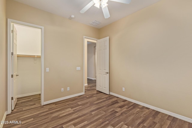 unfurnished bedroom with visible vents, baseboards, wood finished floors, a closet, and a ceiling fan