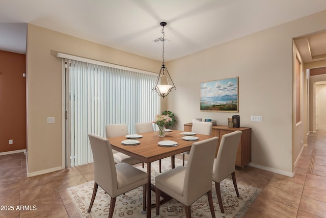 dining space featuring light tile patterned floors, visible vents, and baseboards