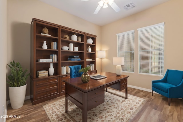 office space featuring visible vents, baseboards, light wood-type flooring, and ceiling fan