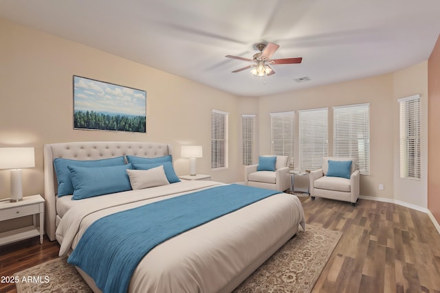 bedroom featuring visible vents, a ceiling fan, baseboards, and wood finished floors