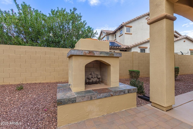 view of patio / terrace featuring exterior fireplace and a fenced backyard