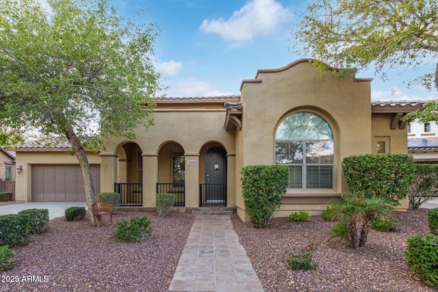 mediterranean / spanish home with a tile roof, a garage, driveway, and stucco siding