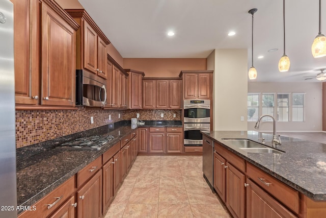 kitchen with tasteful backsplash, brown cabinetry, stainless steel appliances, a ceiling fan, and a sink