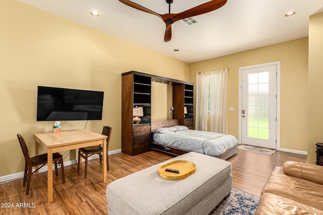 bedroom with hardwood / wood-style floors, access to outside, and ceiling fan