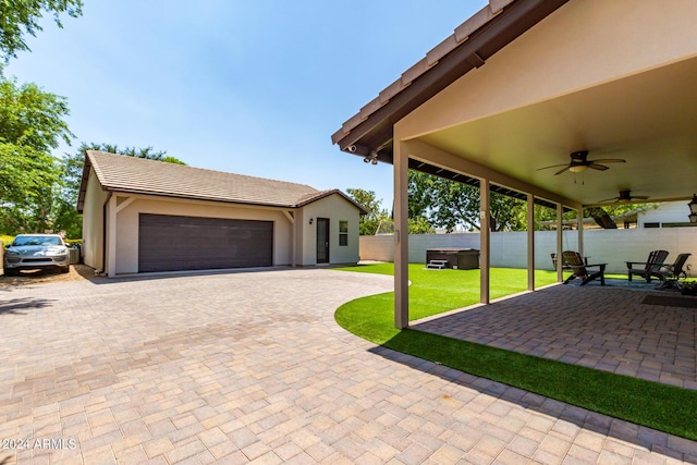 view of patio / terrace with a garage and ceiling fan