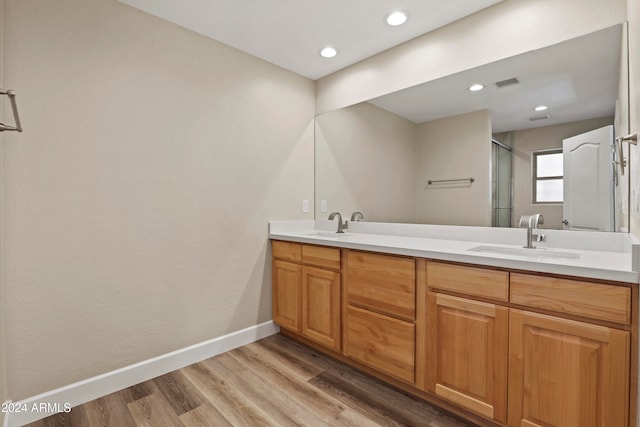 bathroom featuring hardwood / wood-style floors, vanity, and a shower with door