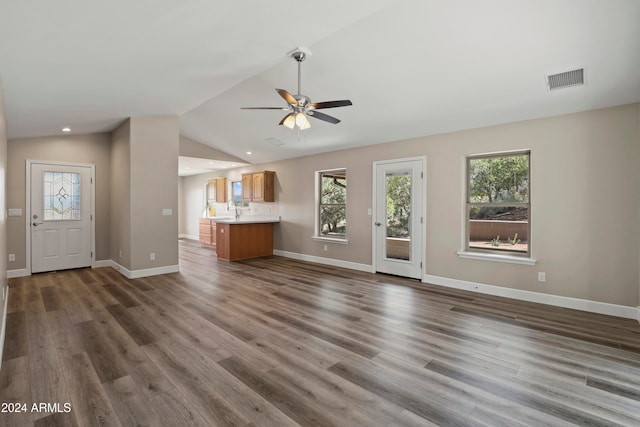 unfurnished living room featuring ceiling fan, sink, dark wood-type flooring, and vaulted ceiling